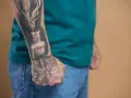 Męskie wzory tatuaży na przedramieniu: płonąca świeca i głowa tygrysa.
