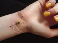 Delikatny tatuaż dmuchawca na nadgarstku, z puszczonymi w wiatr nasionkami. Symbol nadziei i nowego początku, jakby odrodzenie po trudnym okresie.