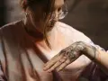 Kobieta z nowym tatuażem na dłoni, zastanawia się, czym myć świeży tatuaż, by zapewnić mu najlepszą pielęgnację.