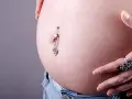Zakażenie kolczyk w pępku objawia się zaczerwienieniem skóry wokół. Dziecko rośnie, a brzuszek się zaokrągla.