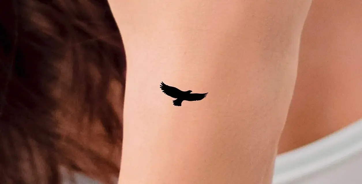 Mały tatuaż orzeł w locie na skórze. Symbol wolności i siły.