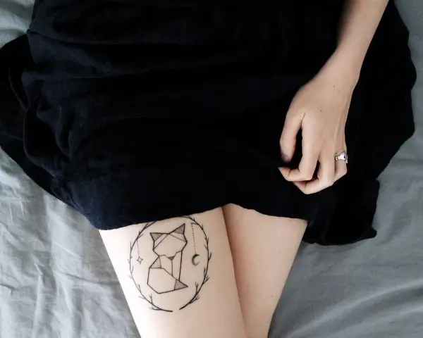 Geometryczny tatuaż lisa w okręgu gałązek. Nawet tatuaż po 30 latach wygląda świetnie.
