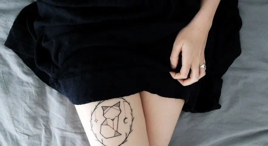 Geometryczny tatuaż lisa w okręgu gałązek. Nawet tatuaż po 30 latach wygląda świetnie.