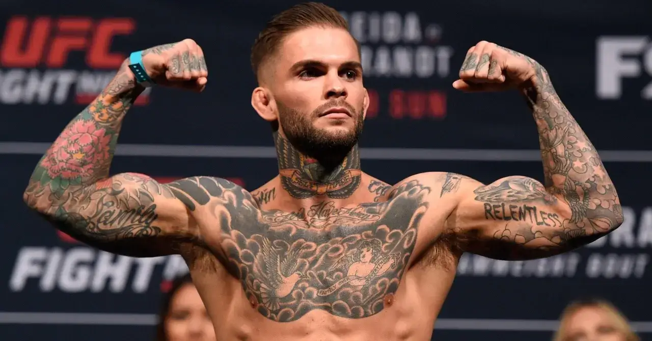 Wojownik UFC z imponującym tatuażem MMA na klatce piersiowej i ramionach, prezentuje swoją siłę.